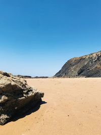 Scenic view of desert against clear blue sky