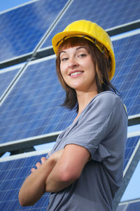 Low angle portrait of confident architect standing against solar panels