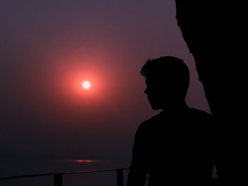 Silhouette man standing against sky during sunset