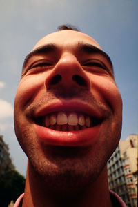 Close-up of smiling man against sky