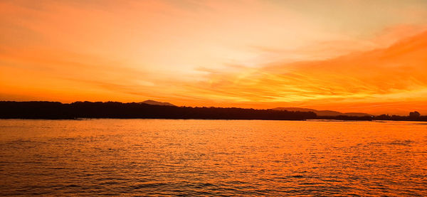 Scenic view of sea against romantic sky at sunset