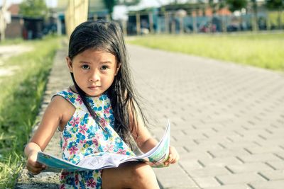 Portrait of cute girl sitting outdoors
