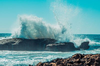 Waves splashing on rocks against sea