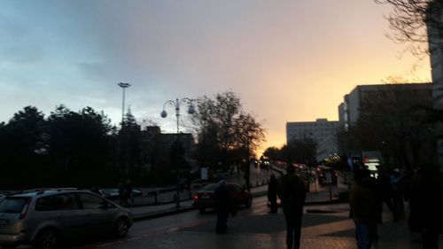 Cars on street in city at sunset