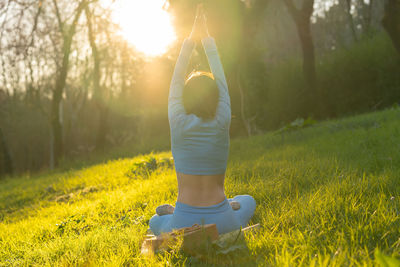 Woman with umbrella on field in forest