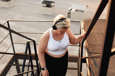 High angle view of woman standing on railing