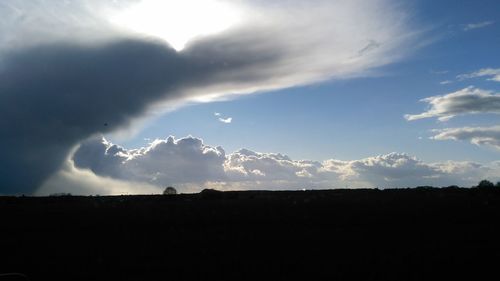 Silhouette of landscape against cloudy sky