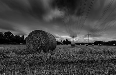 Hay bales on field against sky