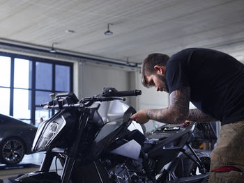 Maintenance engineer repairing vehicle seat at auto repair shop