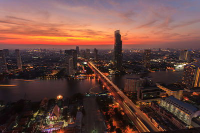 Aerial view of illuminated cityscape against sky at night