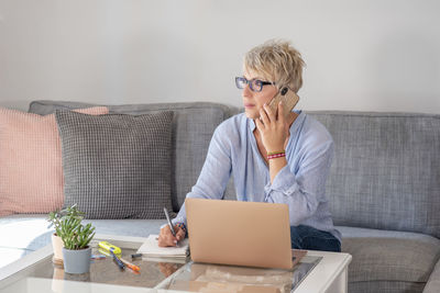 Woman using laptop on couch at home