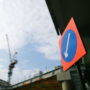 Low angle view of road sign against sky