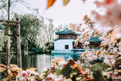 Traditional building by river against sky