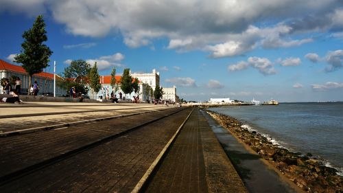 Surface level of footpath by sea against sky