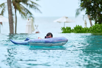 Child play buoyant in swimming pool