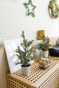 Christmas tree in a pot on the bedside table in the bedroom in scandinavian style