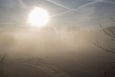 Scenic view of landscape against bright sun