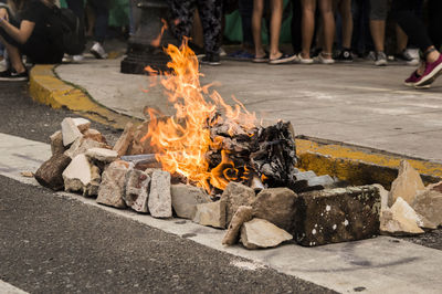 Low section of people by fire on street in city