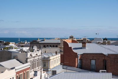 Buildings in city against clear blue sky