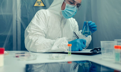 Scientist writing on clipboard in laboratory