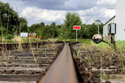 Railroad tracks by trees against sky