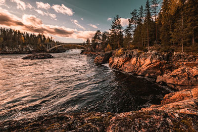 Scenic view of river against sky at sunset