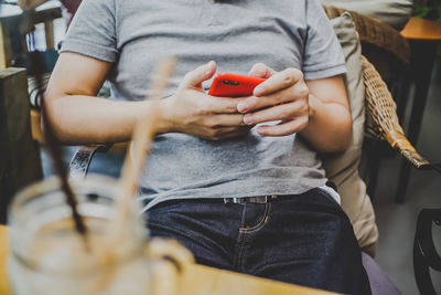 Midsection of man using mobile phone