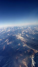 Aerial view of dramatic landscape against blue sky