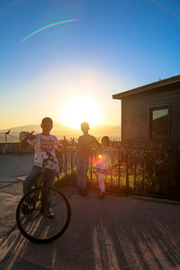 Rear view of people riding bicycle on street