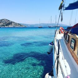 Boats sailing in sea against clear sky