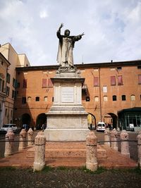 Statue of historic building against cloudy sky