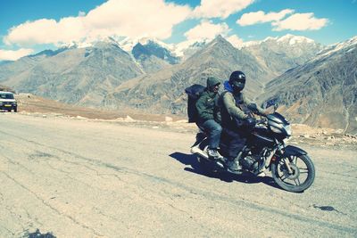 Man riding motorcycle on mountain against sky