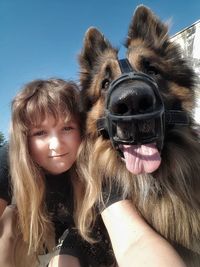 Portrait of girl with dog against clear sky