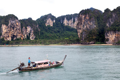 Boat in sea against mountains