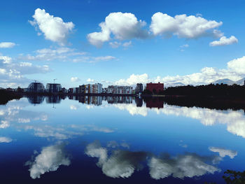 Scenic view of lake by buildings against sky