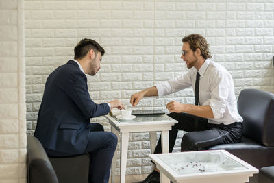 Businessmen discussing while sitting at table in office