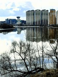 Reflection of buildings in river against sky