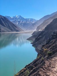 Scenic view of lake and mountains against blue sky