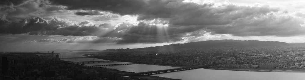 Panoramic view of city against cloudy sky