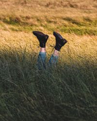 Low section of woman with feet up on field