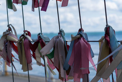 Close-up of textile pieces hanging against sky