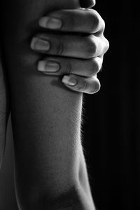 Close-up of human hand against black background