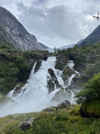 Scenic view of waterfall against sky