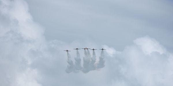 Low angle view of airplane flying against sky