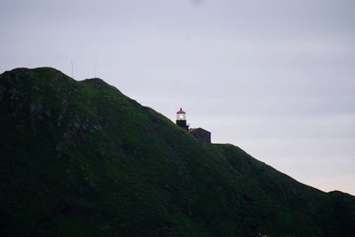 Low angle view of mountains by point sur lighthouse against sky