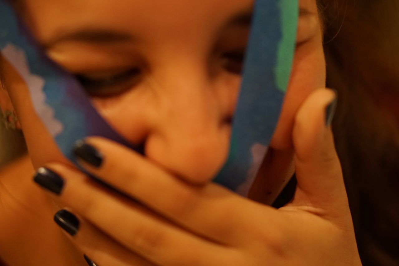 CLOSE-UP OF GIRL HOLDING SMART PHONE