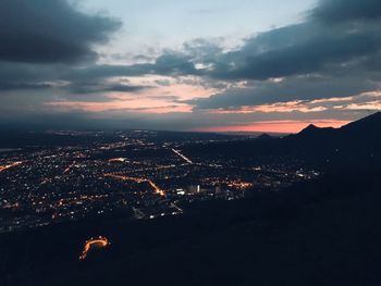 High angle view of illuminated buildings in city at sunset