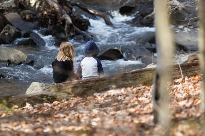 Rear view of children against stream