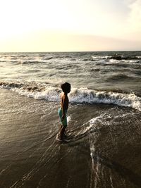 Boy on beach against sky