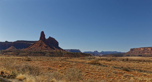 Rock formations on landscape against clear blue sky